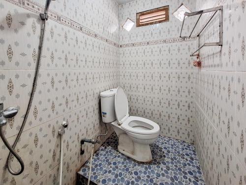 a bathroom with a toilet and a shower in it at Homestay Sakinah Syariah Mitra RedDoorz in Bukittinggi