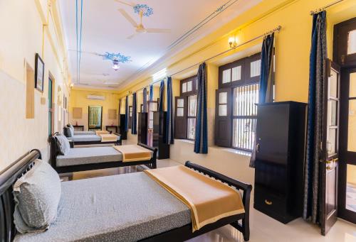 Kalyan Villa Homestay في أودايبور: غرفة بسريرين واريكة
