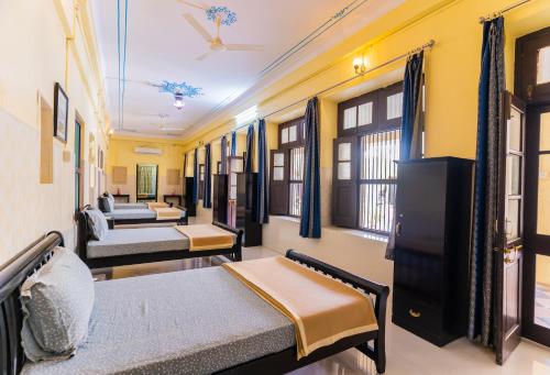 ウダイプールにあるKalyan Villa Homestayのベッド2台とソファのある部屋