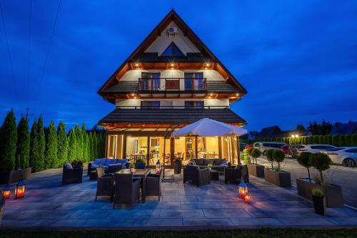 a large building with tables and chairs at night at Parzenica B&B - Wyjątkowa i Jedyna!!! Sprawdź nas a nie pożałujesz! in Białka Tatrzanska