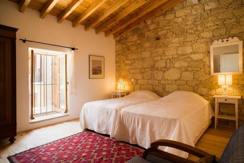 a bedroom with a bed and a stone wall at Modus Vivendi Holidays Arsos in Arsos