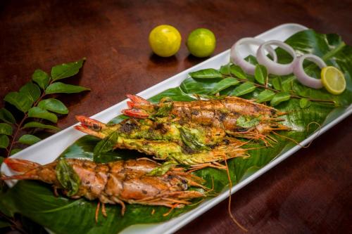 a plate of food with lobsters on top of leaves at Sterling Vythiri Wayanad in Wayanad