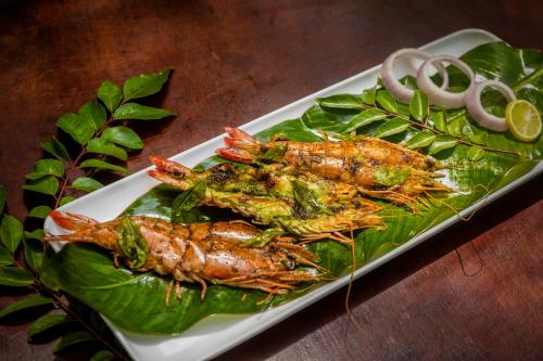 a plate of food with lobsters on top of leaves at Sterling Vythiri Wayanad in Wayanad
