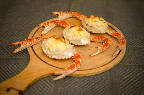 a wooden cutting board with four crabs on it at Sterling Vythiri Wayanad in Wayanad