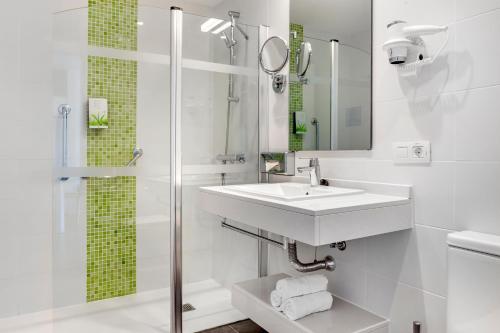 a white bathroom with a sink and a shower at Club del Carmen in Puerto del Carmen