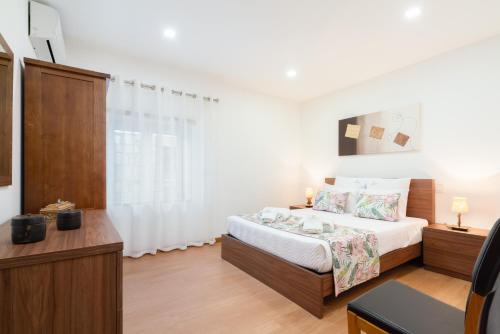 a bedroom with a bed and a tv in a room at Casa da Petisqueira 61 - Paredes-Oporto in Rebordosa