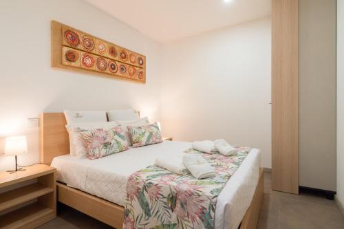 a bedroom with a bed with white sheets and pillows at Casa da Petisqueira 61 - Paredes-Oporto in Rebordosa