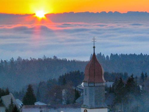 a church with a cross on top of a building at Landhotel Dorfschmiede Konditorei-Café-Restaurant in Höchenschwand