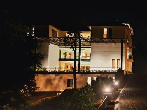 a white building with a balcony at night at Viceroy Luxury Mountain Resort and Spa in Munnar