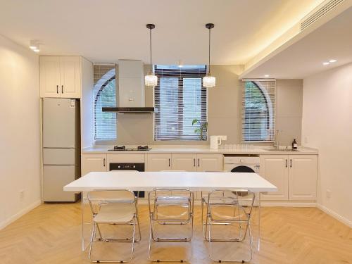 a kitchen with a large white table and chairs at ZHome-Three floors 4 bedrooms - near Nanjing Road in Shanghai