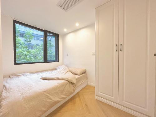 a small bedroom with a bed and a window at ZHome-Three floors 4 bedrooms - near Nanjing Road in Shanghai