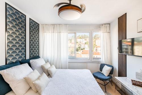 a bedroom with a bed and a chair and a window at SARAH - Design Studio Lumineux Bergson in Saint-Étienne