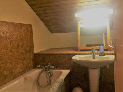 Un baño con lavabo, bañera y espejo. en Appartement 3 pièces 6 couchages à Risoul, calme et proche des pistes - FR-1-330-310, en Risoul