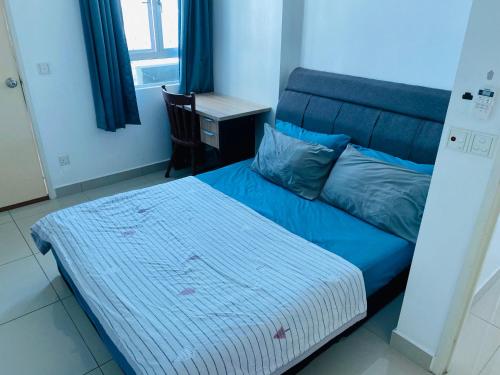 a bedroom with a blue bed and a desk at Spice Tunas House in Bayan Lepas
