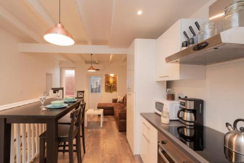 une cuisine et un salon avec une table dans une pièce dans l'établissement L'Aubuisson - Apt Climatisé Avec Terrasse Privée, à Toulouse