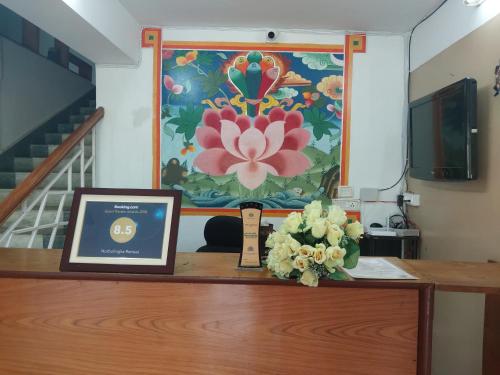 a picture on top of a table with a flower painting at Norbulingka Retreat in Gyalzing