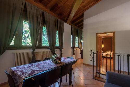 - une salle à manger avec une table, des chaises et des fenêtres dans l'établissement Villa Zarri Guest House, à Castel Maggiore