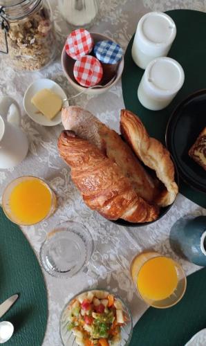 ein Tisch mit Brot und anderen Speisen darauf in der Unterkunft Le Manoir de la Beslière - Gîte et Chambres d'hôtes in Folligny
