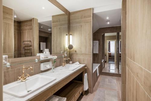 a bathroom with two sinks and a large mirror at Relais & Châteaux Stikliai Hotel in Vilnius