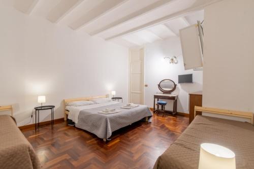 um quarto branco com duas camas e uma mesa em MARIANO APARTMENT em Palermo