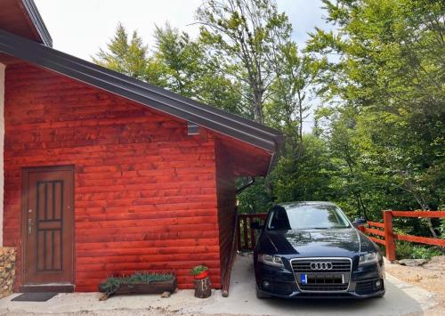 a car parked in front of a red building at Mountain apartment ''Michelle'' in Kakanj