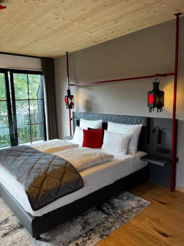 a bedroom with a large bed with red pillows at Ferienbahnhof Reichenbach in Dahn
