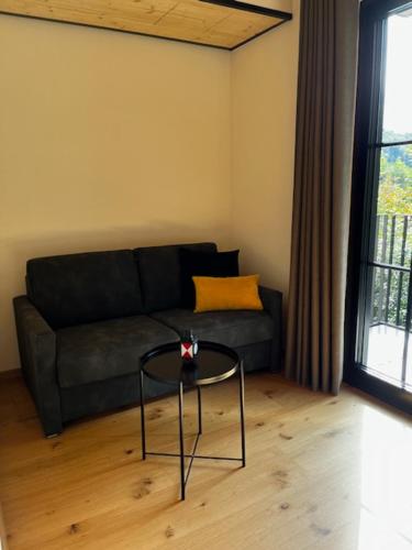 a living room with a black couch and a table at Ferienbahnhof Reichenbach in Dahn
