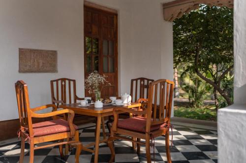 a wooden table and chairs on a porch at LohonoStays Library Sadhrana Bagh in Gurgaon
