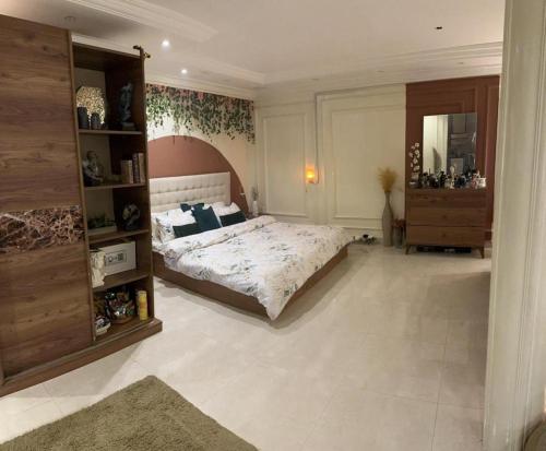 a bedroom with a bed and a dresser in it at شقة مفروشة في المسعودي in Al Ain