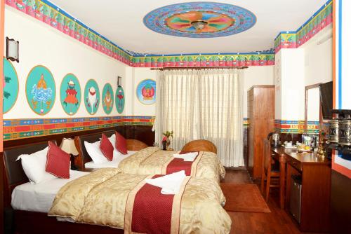 una camera da letto con due letti e una scrivania di Kathmandu Eco Hotel a Kathmandu