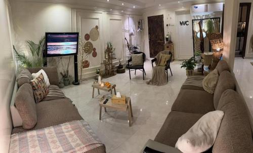 sala de estar con sofás y TV de pantalla plana. en شقة مفروشة في المسعودي en Al Ain