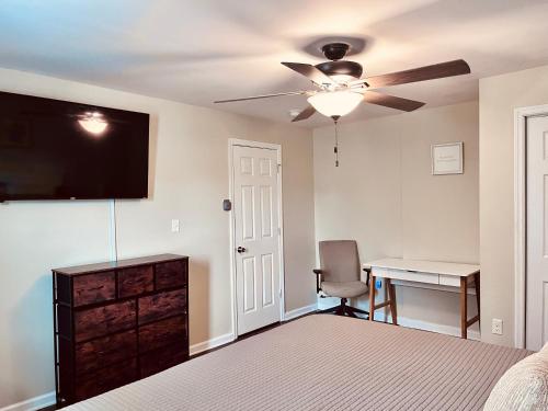 - une chambre avec un lit, un bureau et un ventilateur de plafond dans l'établissement 3 bedroom comfy RVA, à Richmond