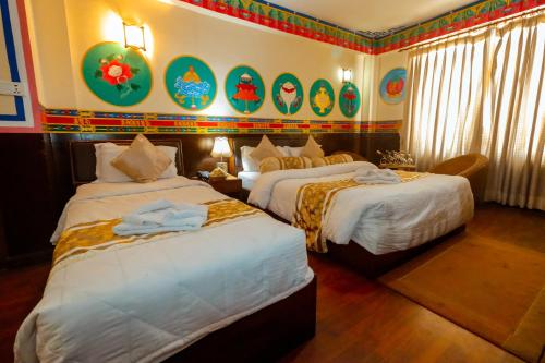 een hotelkamer met 2 bedden en schilderijen aan de muur bij Kathmandu Eco Hotel in Kathmandu