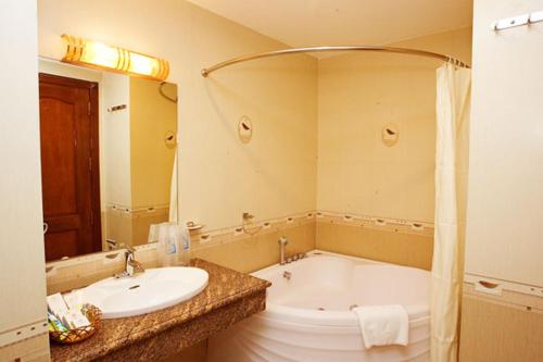 y baño con lavabo y bañera. en Tan Hoang Long Hotel en Ho Chi Minh