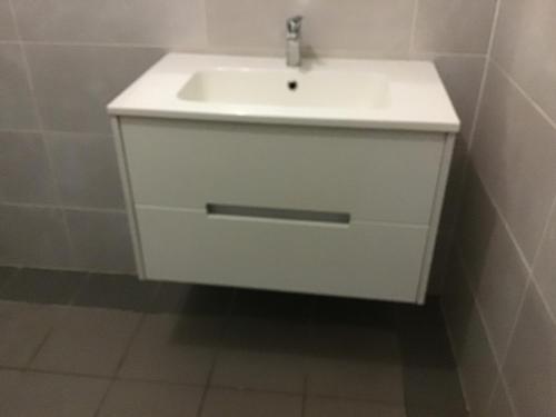 a bathroom with a white sink in a room at Location de meublés in Morne-à-lʼEau