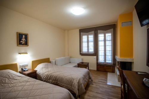 Habitación de hotel con 2 camas y escritorio en Rentinia Inn, en Rentína