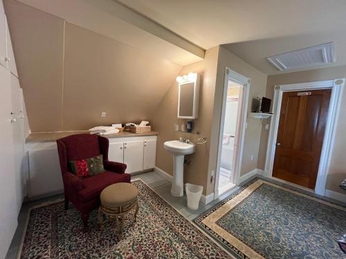 a bathroom with a chair and a sink and a toilet at Cheney House Bed & Breakfast in Ashland