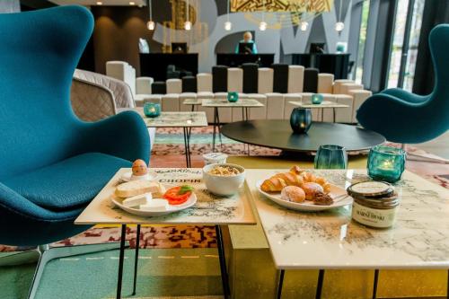 a table with two plates of food and chairs at Motel One Warsaw-Chopin in Warsaw