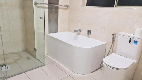 a bathroom with a toilet and a glass shower at 3 Bed Room, Luxury Home in Schofields