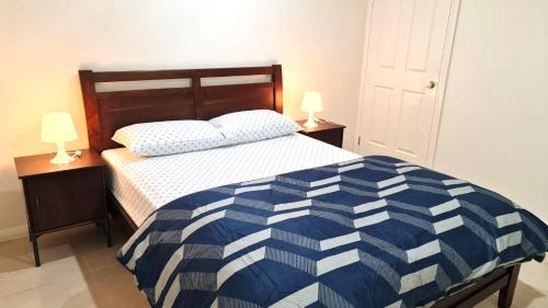 - une chambre avec un lit bleu et blanc et 2 lampes dans l'établissement 3 Bed Room, Luxury Home, à Schofields
