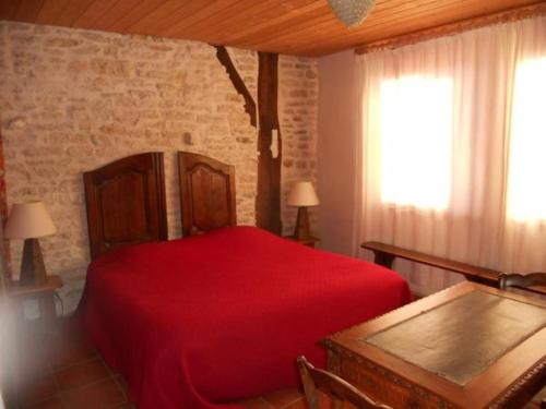 sypialnia z czerwonym łóżkiem i oknem w obiekcie Le Verger Sous Les Vignes w mieście Villeferry
