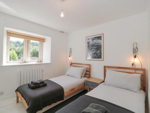 a bedroom with two beds and a window at Abbey Cottage Montacute in Montacute