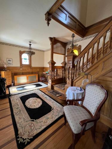 a room with a staircase with a table and chairs at Cheney House Bed & Breakfast in Ashland