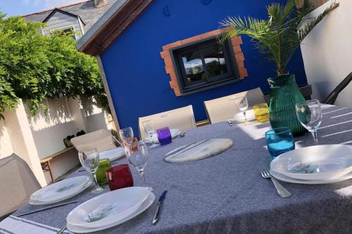 a table with plates and wine glasses on it at Charming House In Pornichet Near The Beach in Pornichet