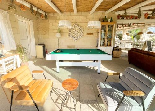 a patio with a pool table and chairs at Masseria Vittoria in Acaya