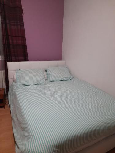 - un lit avec 2 oreillers dans une chambre dans l'établissement Chambre privée dans une maison individuelle, à Ronchin