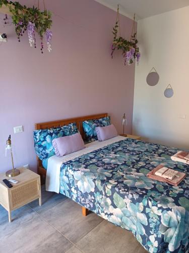 - une chambre dotée d'un lit avec un couvre-lit floral dans l'établissement Le Stanze di Bimba, à Terni
