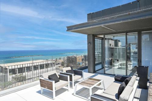 een balkon met witte meubels en uitzicht op de oceaan bij Luxurious 3BR Penthouse with Jacuzzi by HolyGuest in Tel Aviv