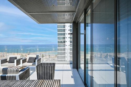 een balkon met stoelen en uitzicht op een gebouw bij Luxurious 3BR Penthouse with Jacuzzi by HolyGuest in Tel Aviv