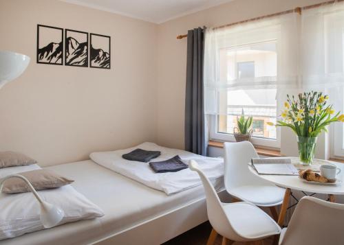 シュクラルスカ・ポレンバにあるPokoje Gościnne Izabelaのベッドルーム1室(ベッド1台、テーブル、椅子付)